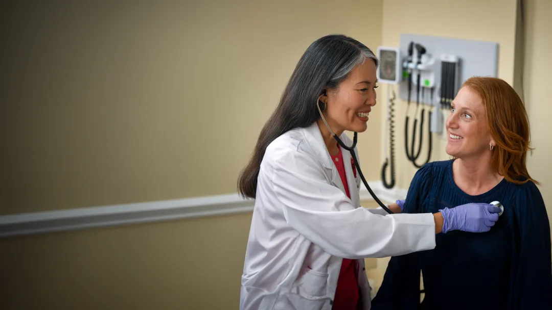 A Provider Checks Her Patient's Vitals in an Exam Room