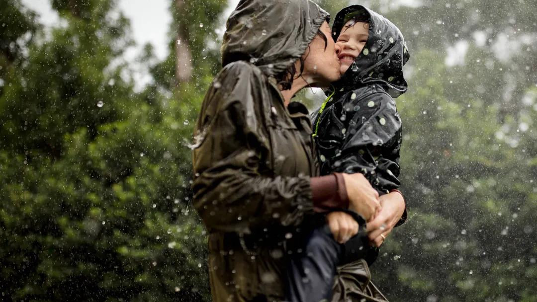Mom and little boy playing in the rain.