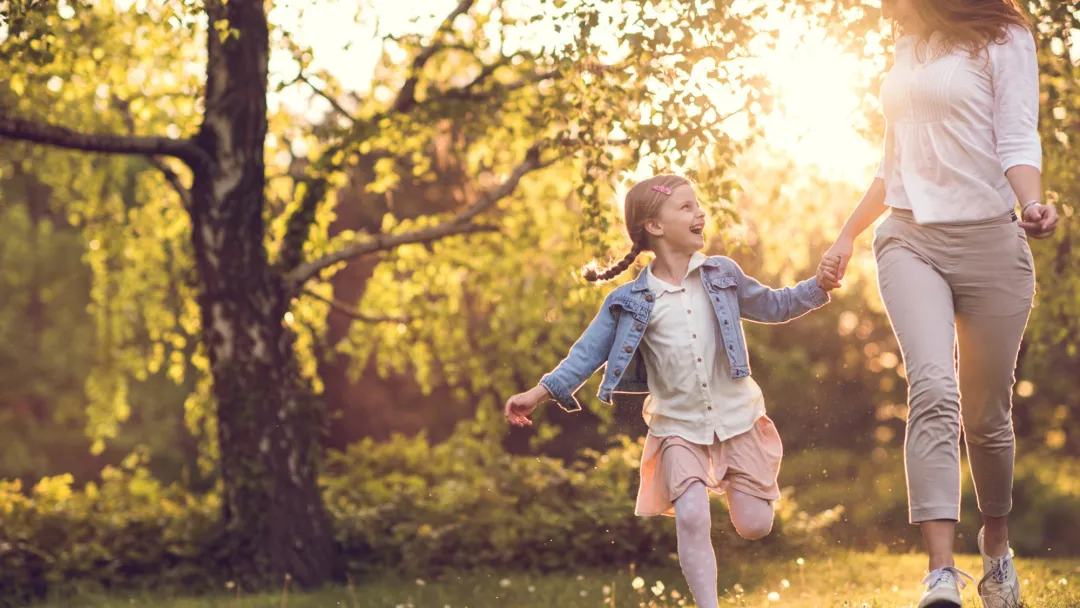 Mother and daughter skipping.