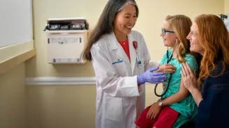 Centra Care Provider Shows a Young Patient How to Listen to Her Heart Beat