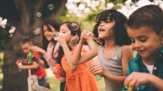 A group happy children blowing bubbles during the summer.