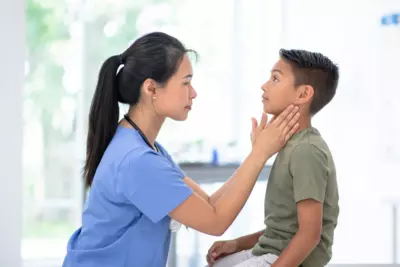 A Physcian Examines a Pediatric Patient's Neck