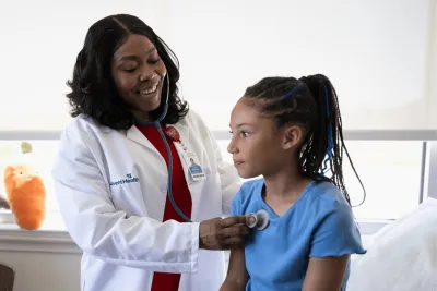 A Physician Checks Her Child Patient's Breathing with a Stethoscope