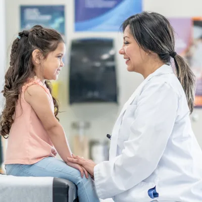 Woman physician smiling and young girl