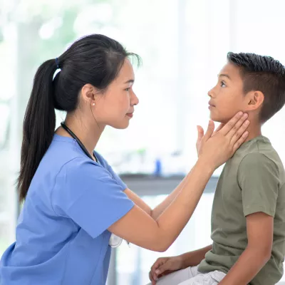 A Physcian Examines a Pediatric Patient's Neck