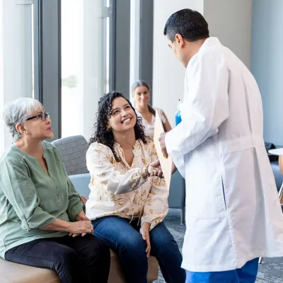 Physician greeting patient and family
