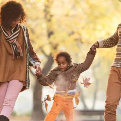 A family walking outside in the fall.
