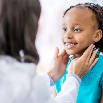 A girl has her throat checked at a doctor's appointment.