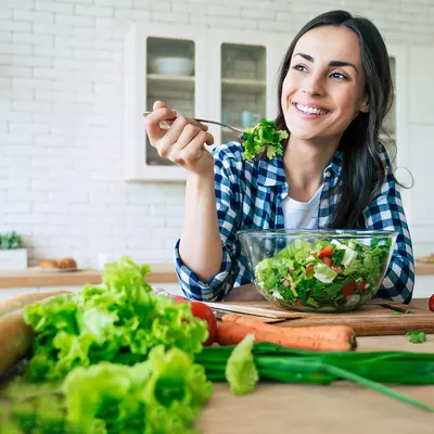 A woman eating a healthy, homemade salad. 
