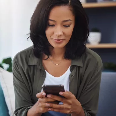 A woman using her mobile phone to book an appointment.