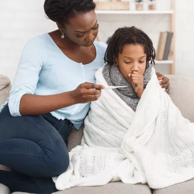A mother taking her sick child's temperature