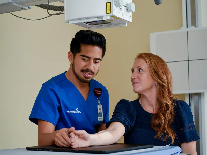 Nurse helping patient get x-ray completed.