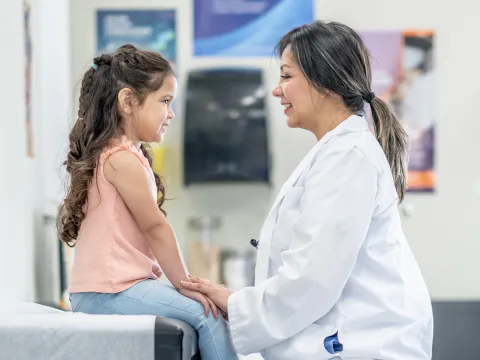 Woman physician smiling and young girl