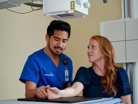 Nurse helping patient get x-ray completed.