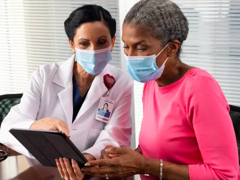 A doctor showing a patient something on her business tablet