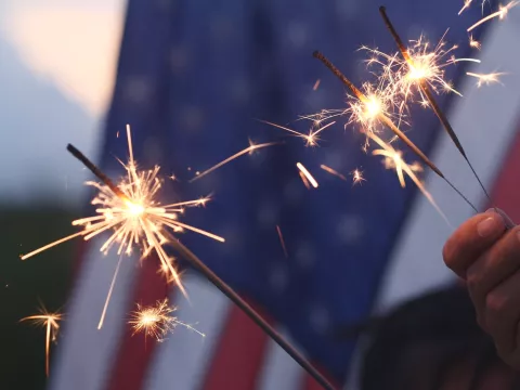 3 Sparklers Burn in Front of The American Flag