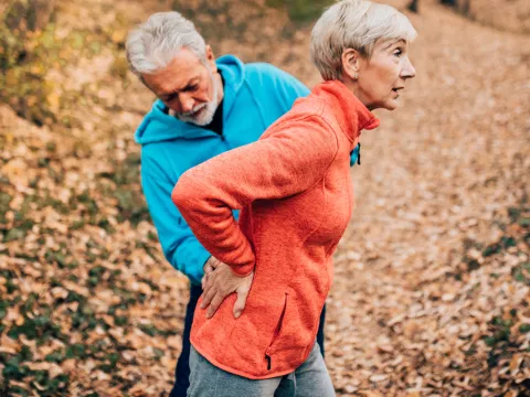 A woman experiences lower back pain during a run.