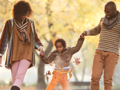 A family walking outside in the fall. 