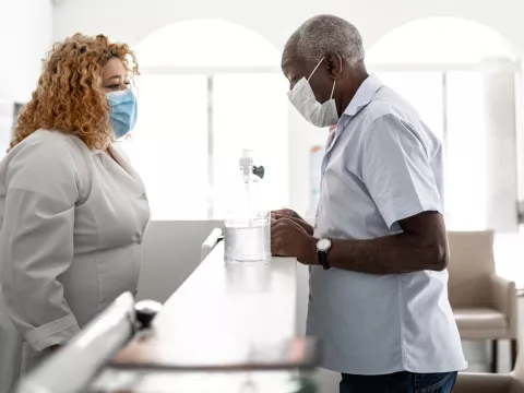 A man wearing a mask checking in for an appointment.