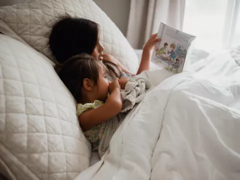 Older child reading to younger child