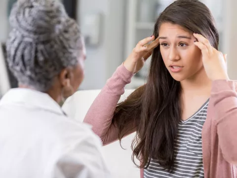 A woman discusses her symptoms with her doctor.