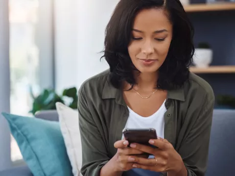 A woman using her mobile phone to book an appointment.