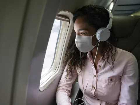 A woman traveling wearing a mask.