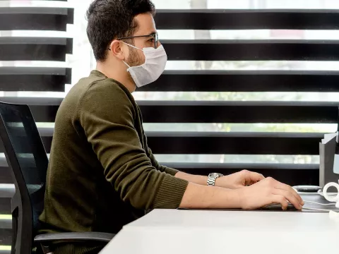 A man at work wearing a face mask.