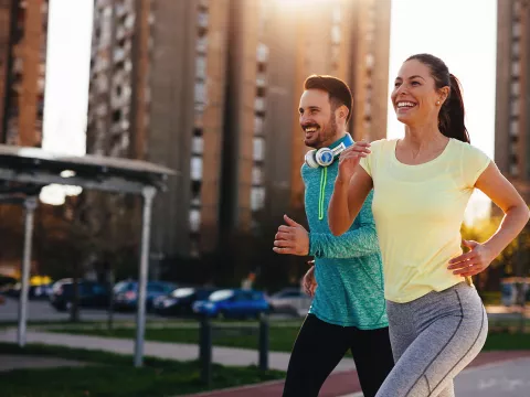 Couple running outside in the city during sunset.