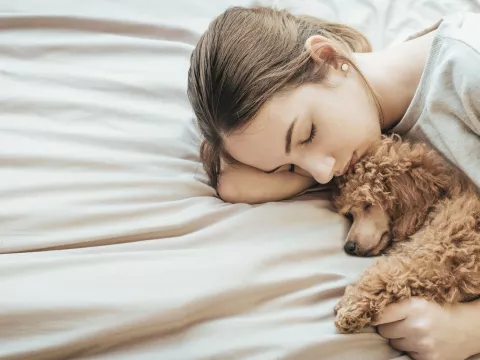 A woman gets some rest with her puppy.