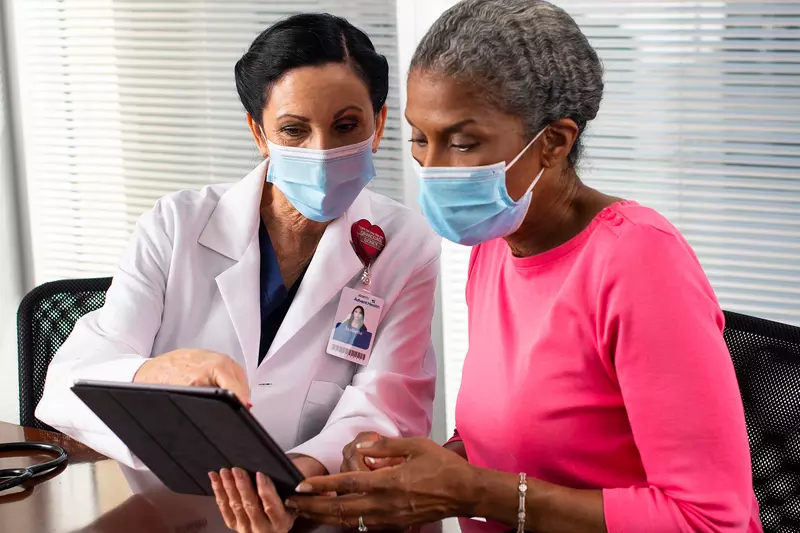 A doctor showing a patient something on her business tablet