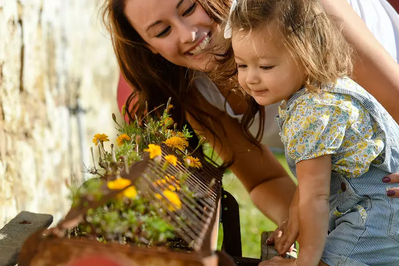 Mother and daughter smelling flowers. 