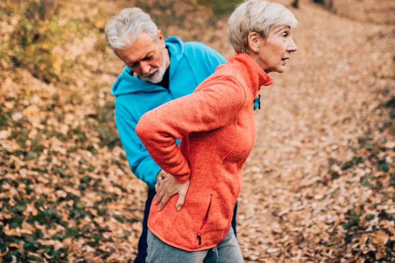 A woman experiences lower back pain during a run.