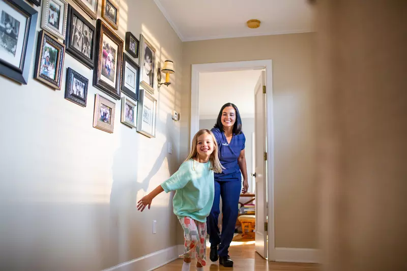 AdventHealth Nurse being led by child down hallway of their home