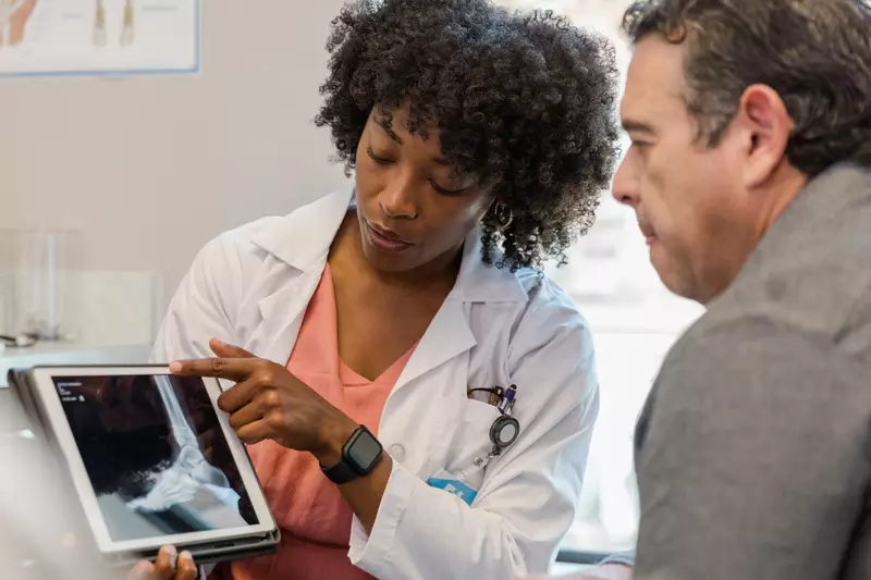 Doctor showing a man an x-ray of his foot.