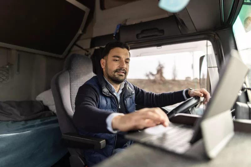 A Commercial Driver Check's the Laptop in His Truck