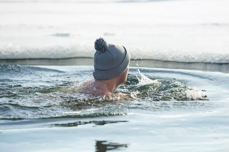 A man taking a swim in cold water.