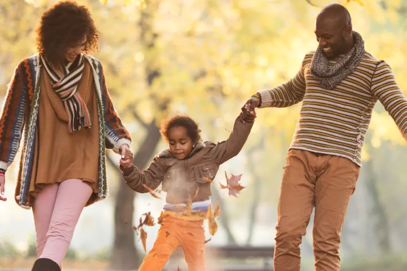 A family walking outside in the fall.