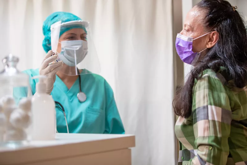 A woman visiting her provider for a flu shot.