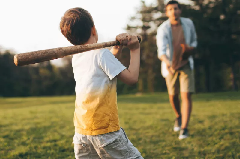 Father and son playing baseball outside