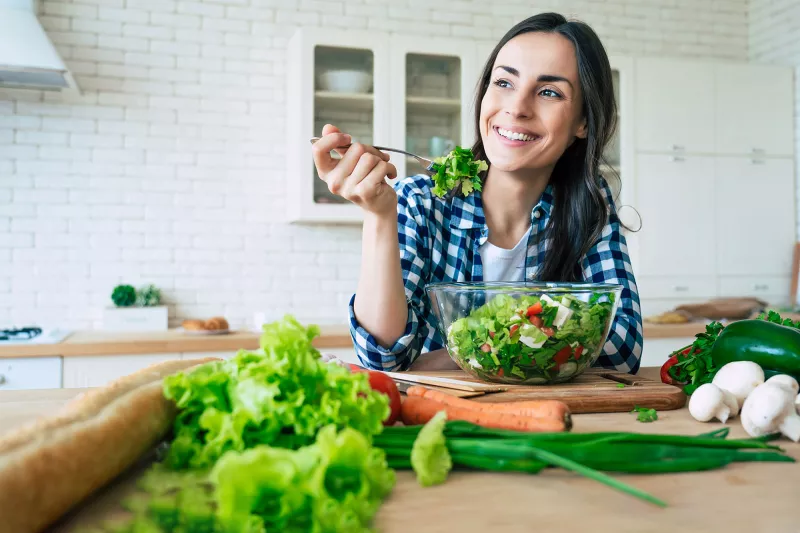 A woman eating a healthy, homemade salad.