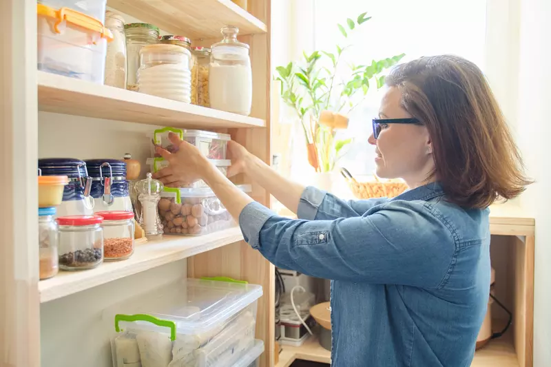 A woman organizing her pantry.