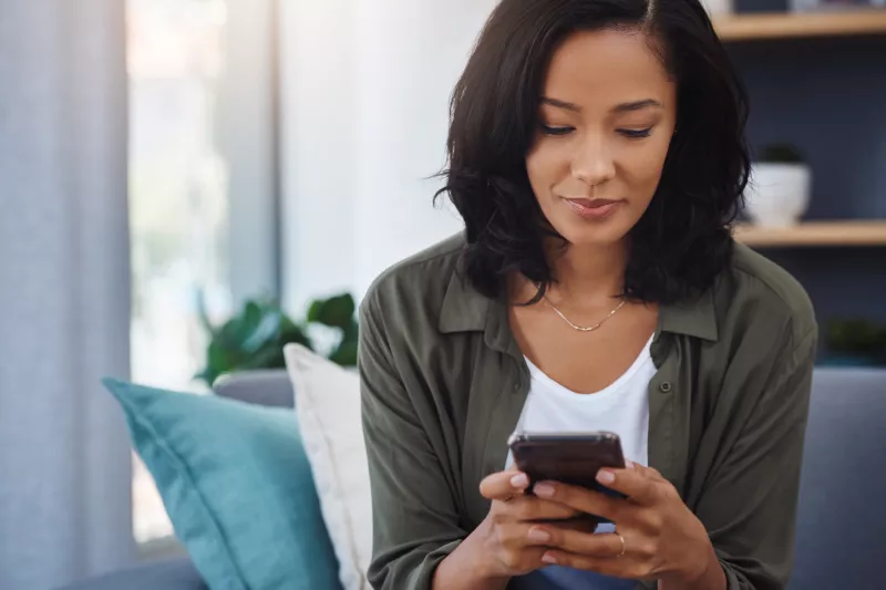 A woman using her mobile phone to book an appointment.