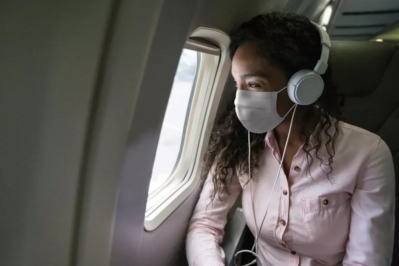 A woman traveling wearing a mask.