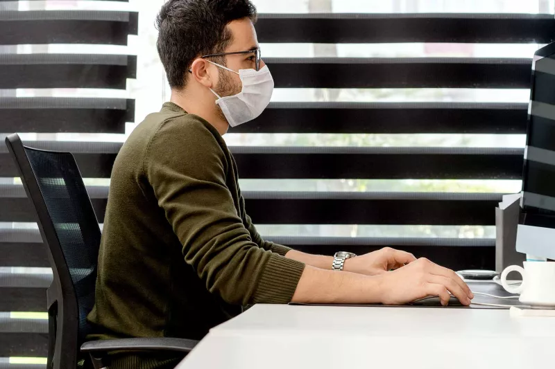 A man at work wearing a face mask.