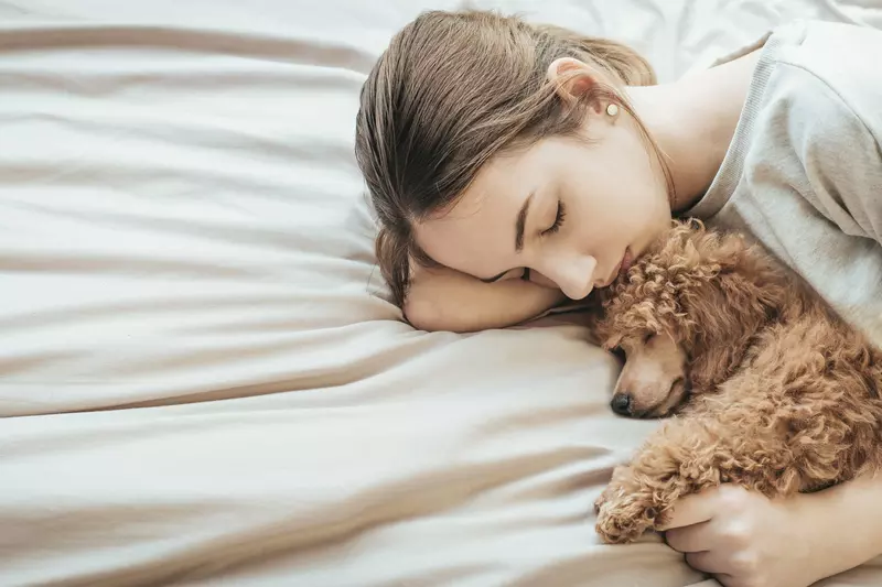 A woman gets some rest with her puppy.