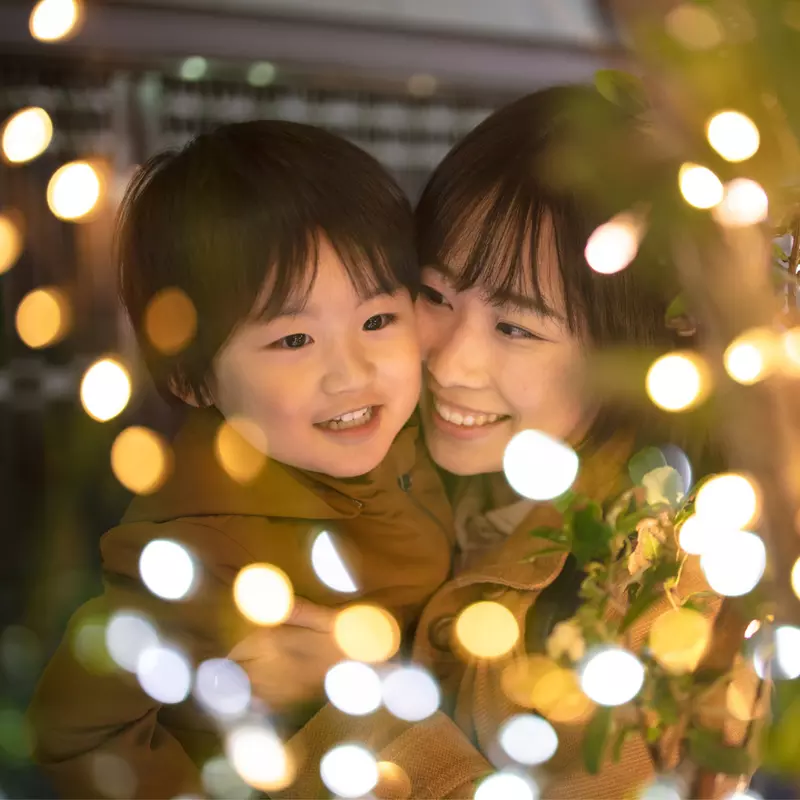 A Mother and Son Enjoy Christmas Lights Outside in the Winter Weather