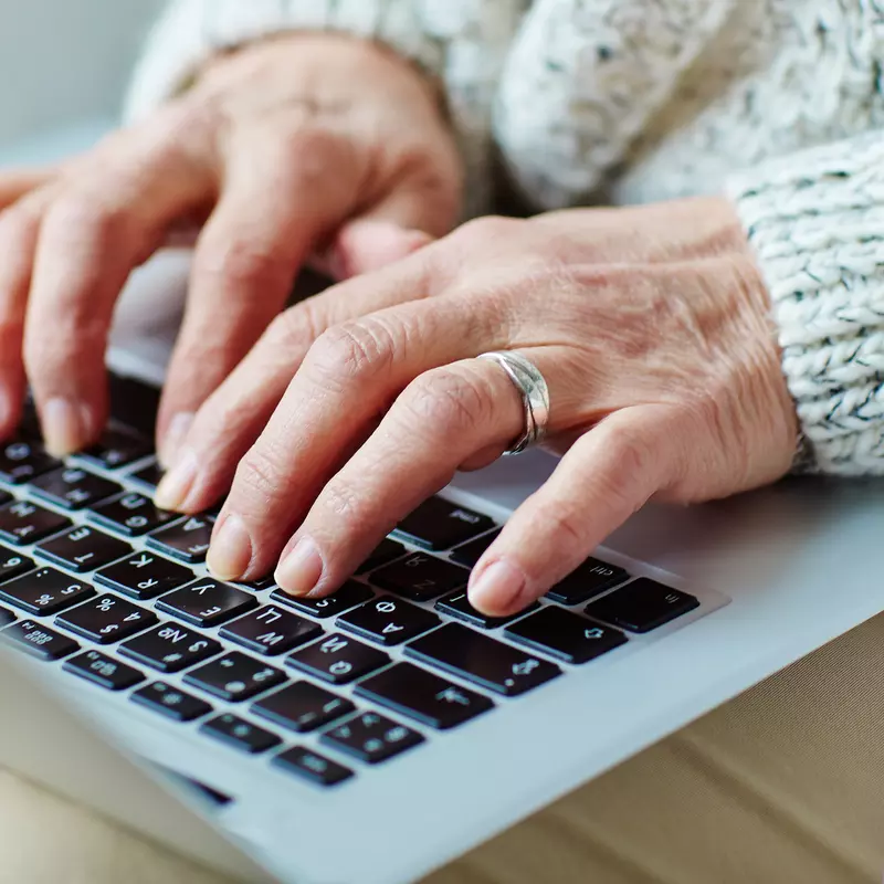 Hands typing on a laptop