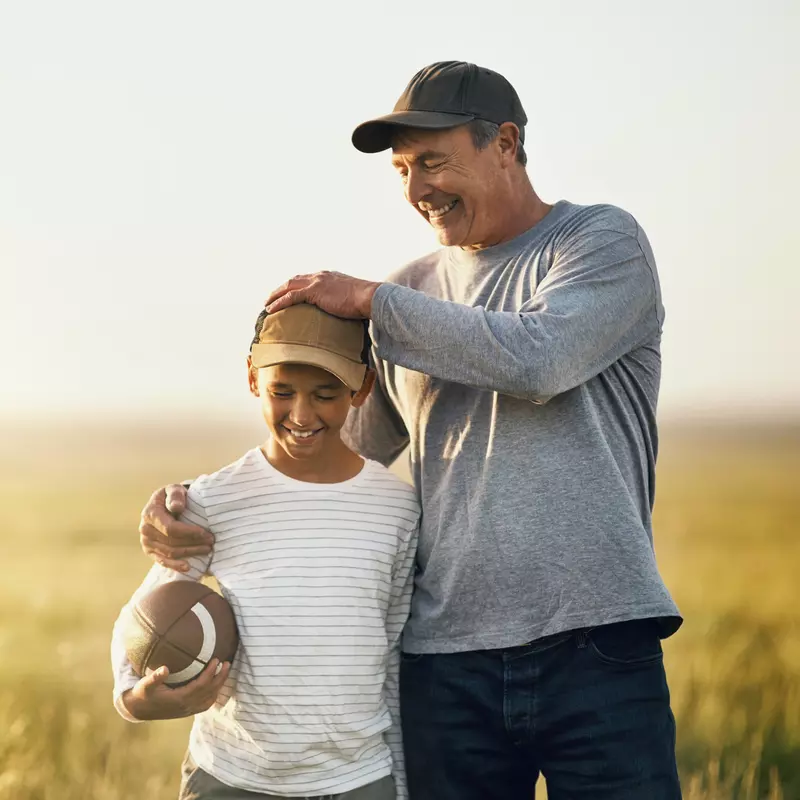 A father hugs his son after a game of football