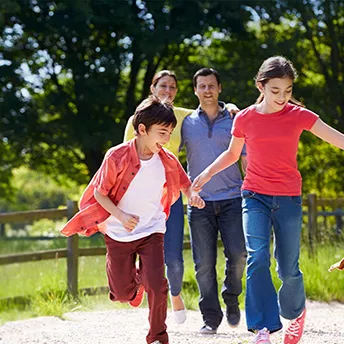 Family walking their dog along a dirt road